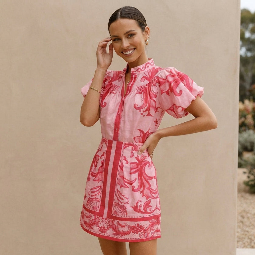 FJØRNA 2-piece set with puff sleeve button-front top and A-line mini skirt, featuring a band collar on a model.