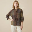 FJØRNA women's summer blouse with geometric pattern and V-neck, worn by a model showcasing casual stylish top.