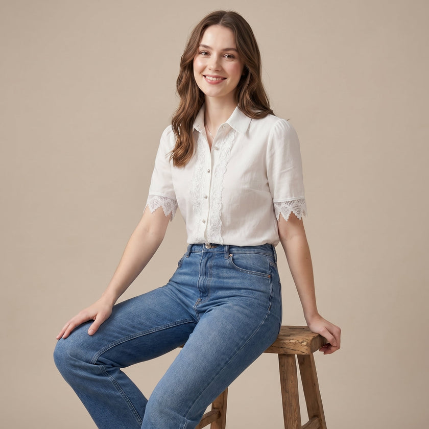 FJØRNA women's summer blouse with V-neck and puff sleeves, made of linen, worn by a model in a casual outdoor setting.