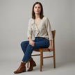 FJØRNA women's summer V-neck denim blouse with ruffle details, modeled on a woman, casual and stylish top for warm weather.