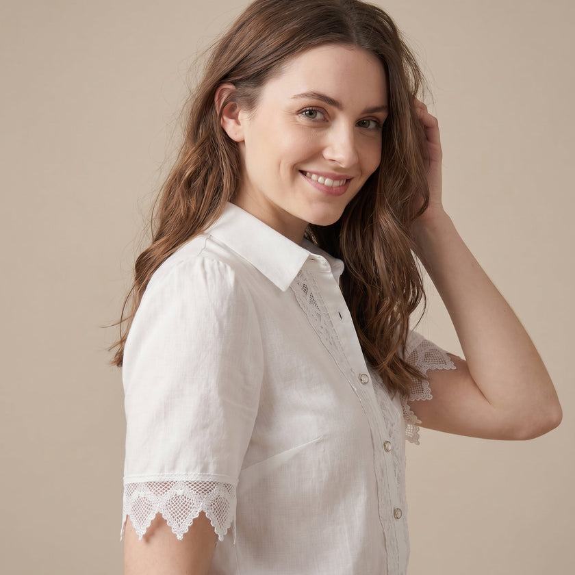 FJØRNA women's summer blouse with v-neck, puff sleeves, made of linen, styled on a model.