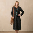 FJØRNA relaxed knit maxi dress with textured pattern and patch pockets, worn by a model showcasing casual, comfortable style.