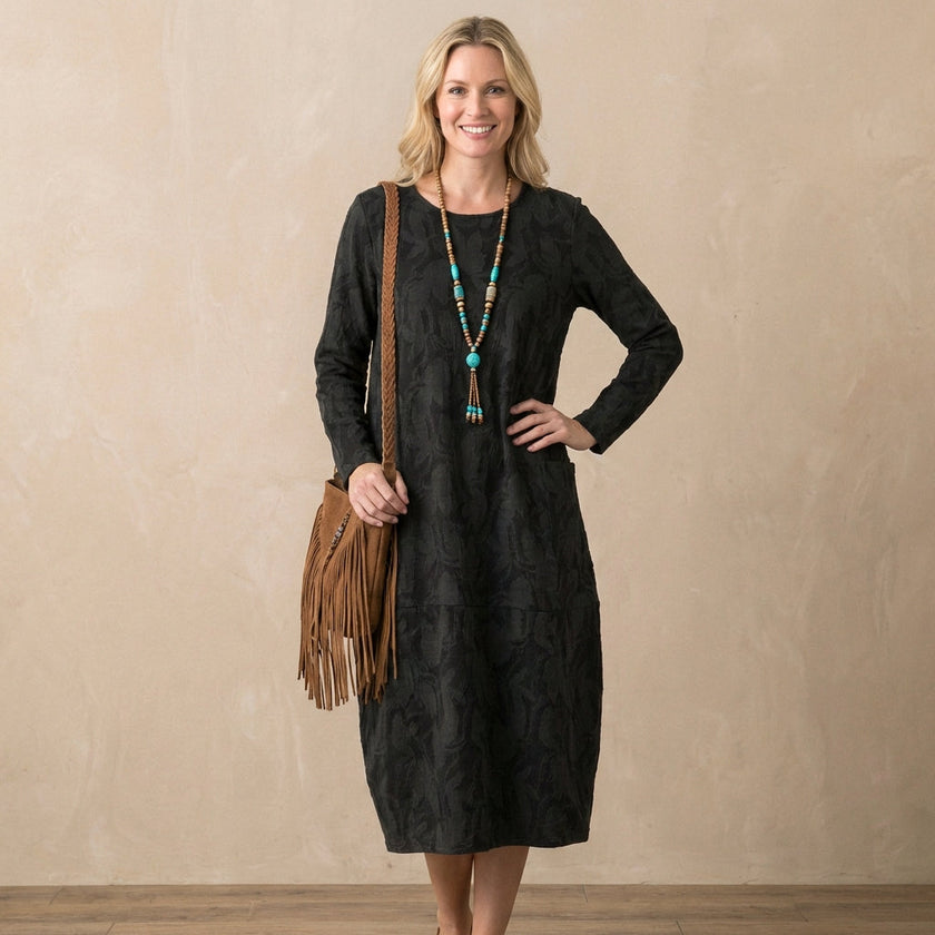 FJØRNA relaxed knit maxi dress with textured pattern and patch pockets, worn by a model showcasing casual, comfortable style.