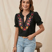 FJØRNA women's summer floral blouse with puff sleeves and ruffle details, worn by a model showcasing a stylish summer top.