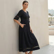 FJØRNA A-line maxi dress with mesh panels and pockets, worn by a model, showcasing its flowing fabric and stylish design.