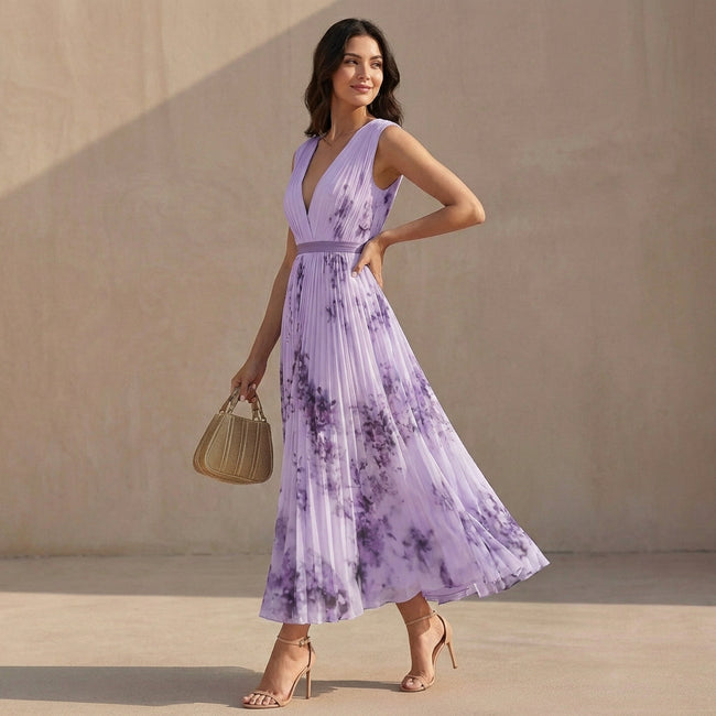 Model wearing FJØRNA pleated A-line maxi dress with V-neck and balloon sleeves, flowing fabric and elegant silhouette.