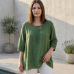 FJØRNA women's summer linen blouse with cut-out design, worn by model, stylish and breathable top perfect for warm weather.