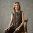 Model wearing FJØRNA summer sleeveless denim blouse with button front, stylish women's top perfect for warm weather.