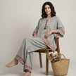 FJØRNA relaxed embroidered trim two-piece lounge set on model, featuring comfortable fabric and stylish embroidered details.