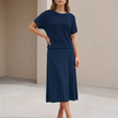 Navy blue FJØRNA flowing midi dress and cropped open-knit mesh top set, shown on a model, highlighting elegant and stylish 2-piece fashion.