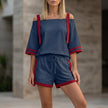 FJØRNA navy blue two-piece set with sporty contrast trim, featuring a relaxed off-shoulder top and matching bottoms.