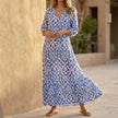 Navy V-neck maxi dress with ruffled hem by FJØRNA, flowing style perfect for elegant summer occasions.
