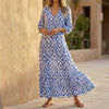 Navy V-neck maxi dress with ruffled hem by FJØRNA, flowing style perfect for elegant summer occasions.
