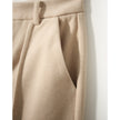 FJØRNA women's wool tapered trousers with a tailored fit, shown in a neutral color, displayed on a model.