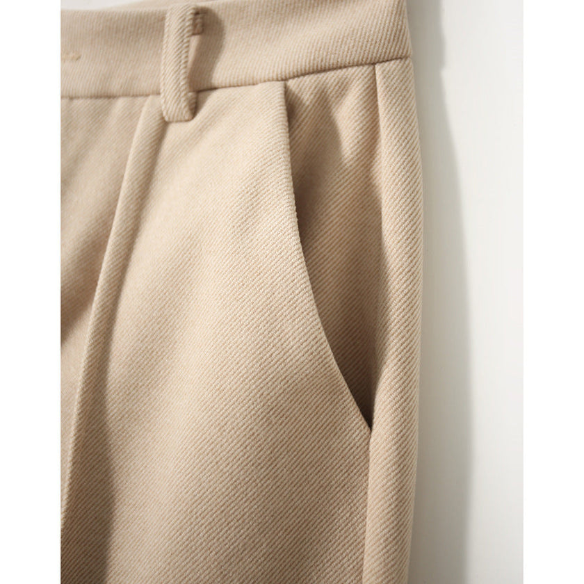 FJØRNA women's wool tapered trousers with a tailored fit, shown in a neutral color, displayed on a model.