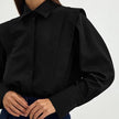 FJØRNA women's cotton blouse featuring a relaxed fit, long sleeves, and a soft, breathable fabric in a versatile design.