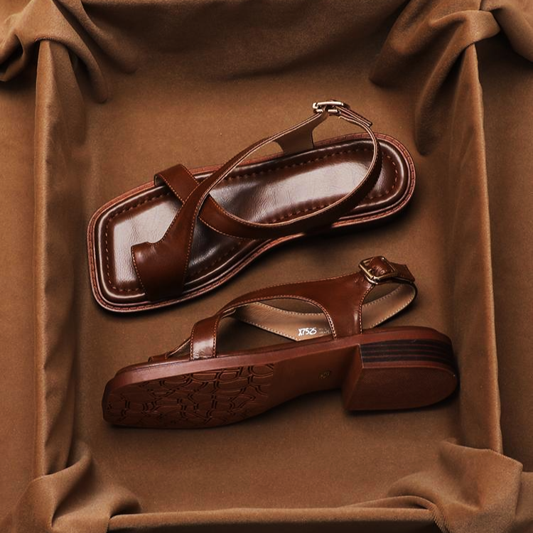 FJØRNA women's Italian leather sandals with adjustable strap and cross design, featuring open toes and flat soles.