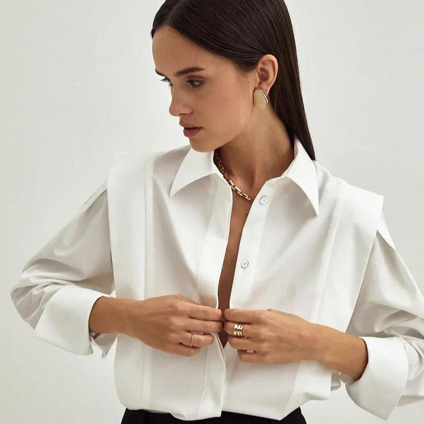 FJØRNA women's cotton blouse, stylish top with long sleeves and a relaxed fit, displayed on a hanger against a neutral background.