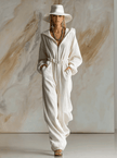 White corduroy hooded zip-front long sleeve jumpsuit by FJØRNA with a front zipper and relaxed fit, displayed on a mannequin.