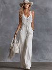 White faux suede Western fringe V-neck jumpsuit by FJØRNA featuring fringe details and a V-neck design.