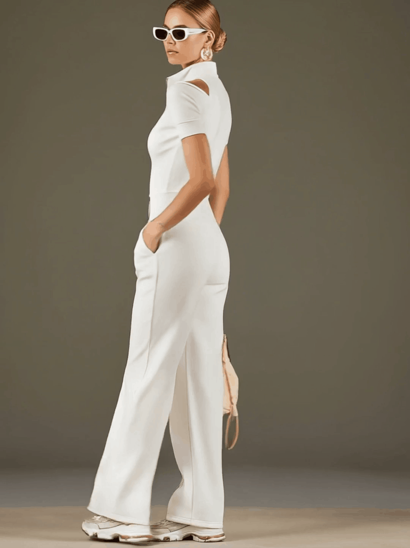 White cotton blend short sleeve wide-leg jumpsuit by FJØRNA, shown on a mannequin with a relaxed fit and stylish design.