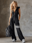 Black striped sleeveless hooded jumpsuit by FJØRNA, featuring a relaxed fit and casual style, shown on a mannequin.