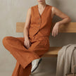 FJØRNA tailored linen sleeveless vest with high-waisted pleated trousers in vibrant orange, stylish 2-piece set for modern fashion.