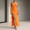 Orange FJØRNA fitted sleeveless maxi dress with ruffled high slit, flowing fabric and elegant design for summer wear.