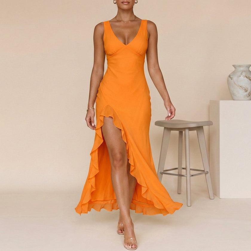 Orange FJØRNA flowing chiffon maxi dress with ruched bodice and ruffled slit, shown hanging on a mannequin.