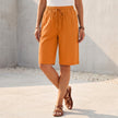 Orange women's summer shorts by FJØRNA with cotton fabric and drawstring waist, casual and comfortable for warm weather.