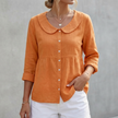 Orange women's FJØRNA relaxed Peter Pan collar shirt with peplum waist, stylish and feminine top for casual or dressy looks.