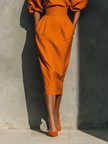 Orange linen midi dress for women by FJØRNA, showcasing a flowy, sleeveless design with a fitted waist and mid-length hem.