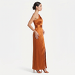 Orange FJØRNA women's one-shoulder maxi evening dress with asymmetric neckline, shown in a side profile view.