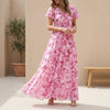 Pink FJØRNA A-line maxi dress with V-neck and flutter sleeves, flowing fabric and elegant design perfect for summer.