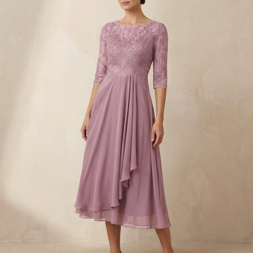 Pink embroidered FJØRNA A-line midi dress with sheer sleeves and side pockets, showcasing elegant detailing and flowy silhouette.