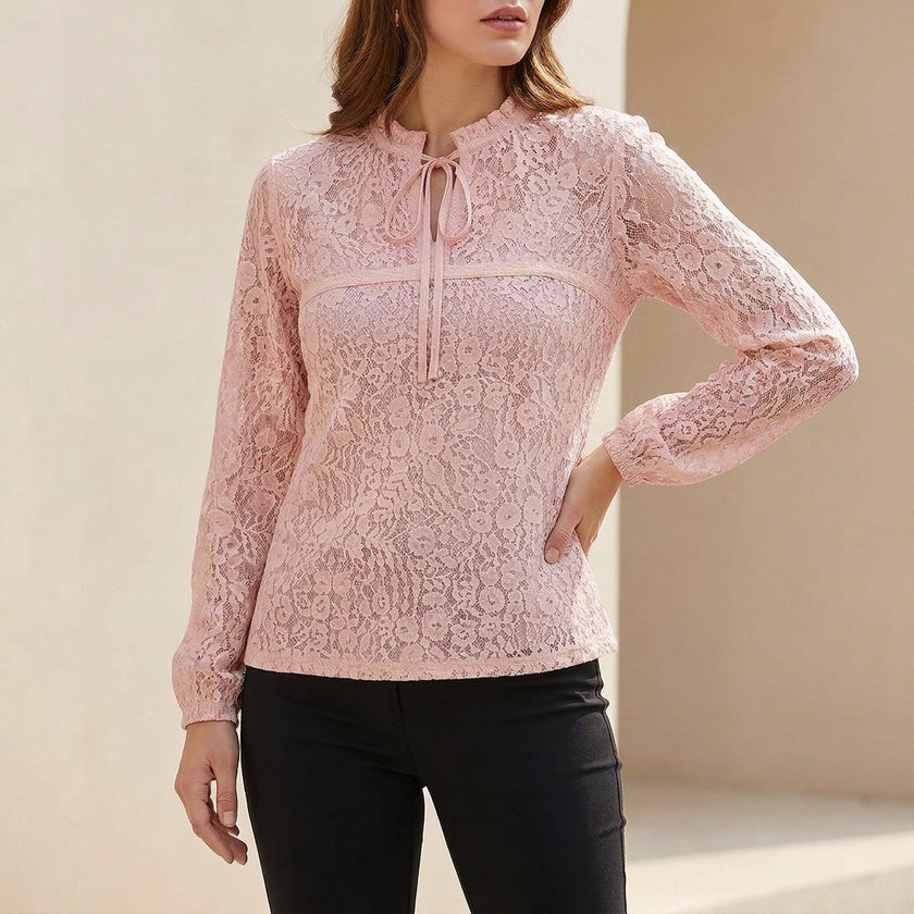 Pink FJØRNA fitted sheer lace blouse with ruffled tie-neck and floral detailing, featuring delicate lace fabric and feminine design.