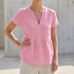 Pink women's V-neck peplum blouse by FJØRNA featuring pintuck detailing and a curved hem, styled on a mannequin.