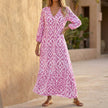 Pink FJØRNA V-neck maxi dress with ruffled hem, flowing fabric, and sleeveless design, perfect for elegant summer occasions.