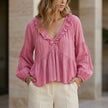Pink women's summer blouse by FJØRNA featuring a V-neck, long sleeves, and ruffle details in denim fabric.
