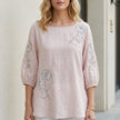 Pink floral summer blouse for women with puff sleeves from FJØRNA, shown on a model showcasing its stylish design.