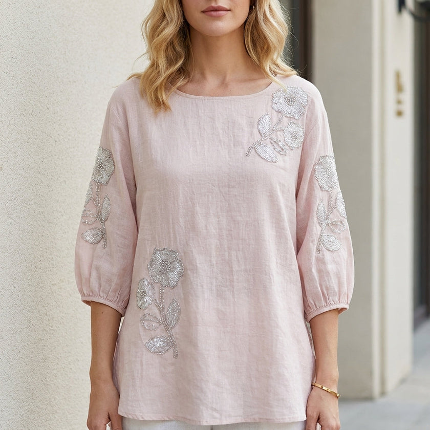 Pink floral summer blouse for women with puff sleeves from FJØRNA, shown on a model showcasing its stylish design.