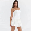 White pleated corset mini dress by FJØRNA, featuring a fitted waist, structured bodice, and stylish pleated skirt for a chic look.