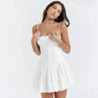 FJØRNA white pleated corset mini dress with structured bodice and flared skirt, perfect for stylish occasions.