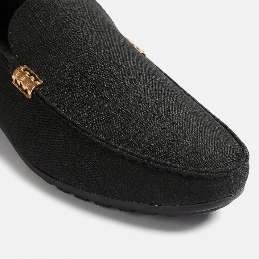 Close-up of FJØRNA men's canvas slip-on loafers showing the textured toe box and casual design details.