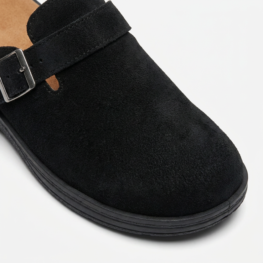 Close-up of men's FJØRNA PU leather mule clogs featuring buckle strap, slip-on casual flat shoes with a rounded toe box.