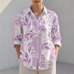 Purple women's tunic shirt by FJØRNA with V-neck, collared design, and roll-tab sleeves, displayed flat on a white background.