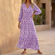 Purple FJØRNA V-neck maxi dress with ruffled hem, flowing fabric, and elegant design perfect for summer or special occasions.