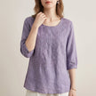 Purple floral V-neck summer blouse for women from FJØRNA, featuring a lightweight, feminine design with a relaxed fit.