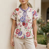 Purple floral summer blouse for women by FJØRNA, short sleeve top with a relaxed fit and feminine design.