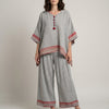 Red FJØRNA relaxed two-piece lounge set with embroidered trim, featuring a comfortable top and matching pants.